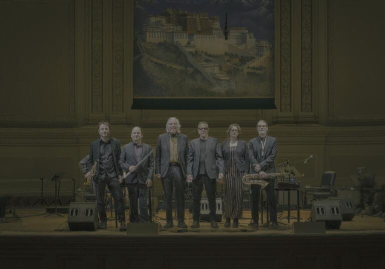The Philip Glass Ensemble stand on stage at Carnegie Hall