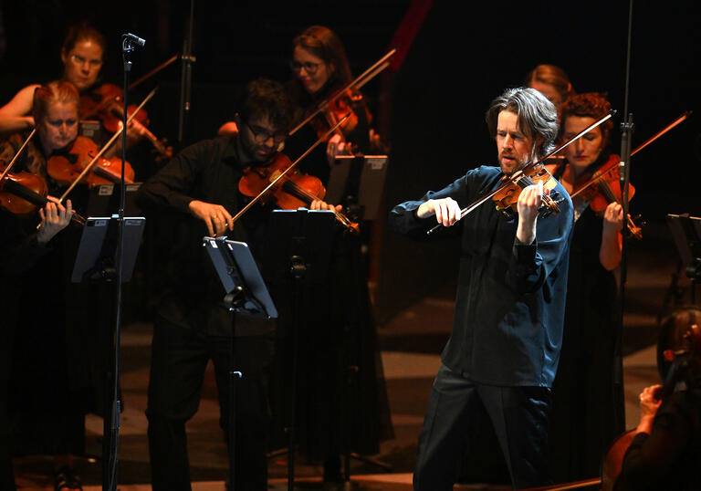 Britten Sinfonia on stage, playing violins