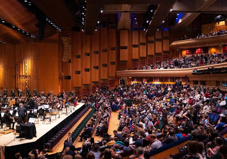 The London Symphony Orchestra on the Barbican Hall stage in front of a full audience of families