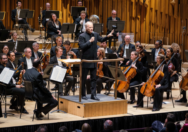 Conductor Gianandrea Noseda holds a microphone and presents his pre-concert Half Six Fix talk