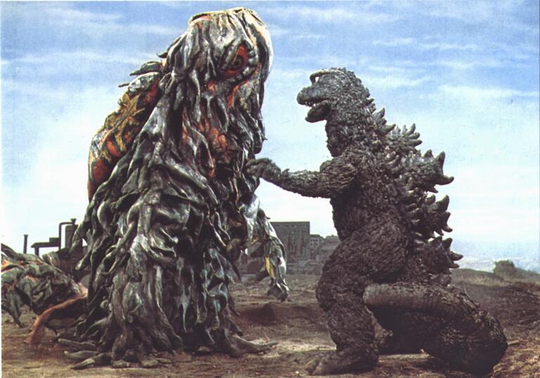 Two monsters battle in a cityscape in this still from the 1970s Godzilla movie.