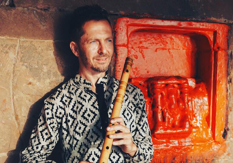 Jason Kalidas holding a bansuri