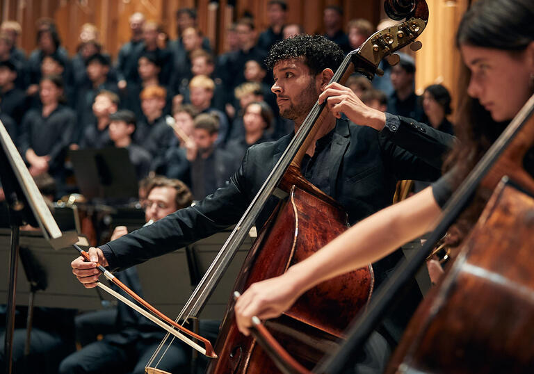 Double bass section with choir in background