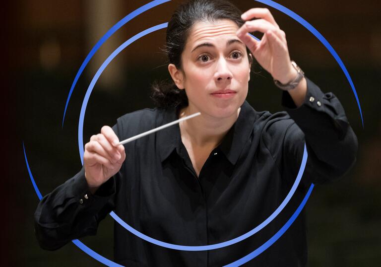 Marie Jacquot conducting, with blue circular swirls around her
