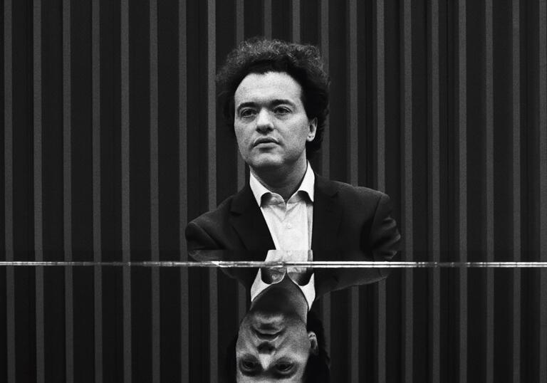 Black and white photo of Evgeny Kissin sitting at a piano