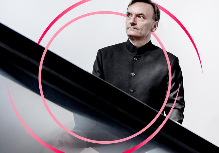 A photo of Stephen Hough with pink circular swirls around him