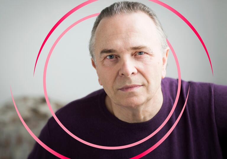 A photo of Mark Elder with pink circular swirls around him