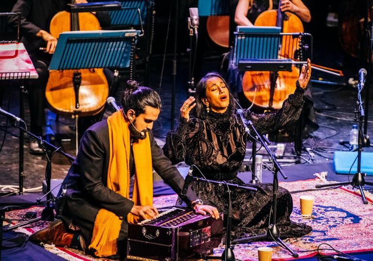 Rushil Ranjan and Abi Sampa sitting on stage performing