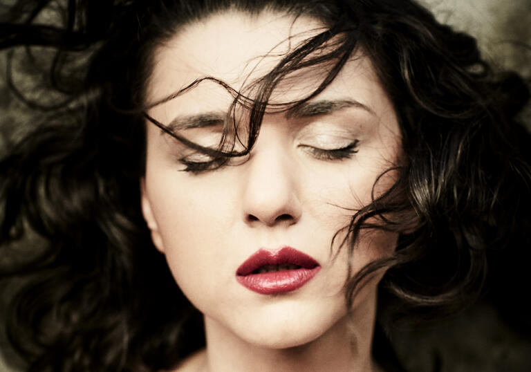 Close up shot of Khatia Buniatishvili with her eyes closed and her hair blowing in her face