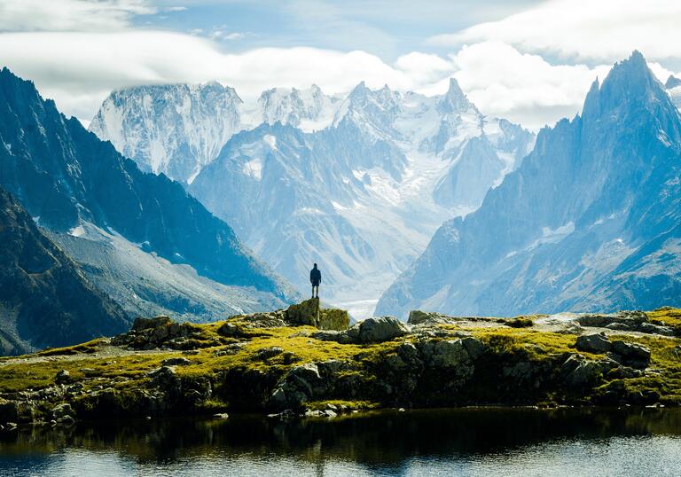 A man looking out at a vast mountainous landscape