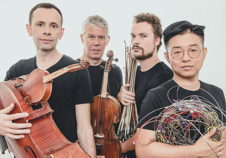 Quatuor Diotima holding broken instruments.