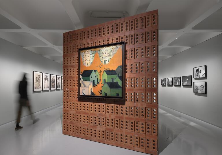orange painting on a brick wall in a gallery