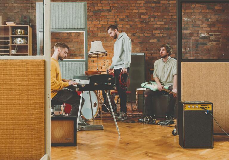 Gotts Street Trio sit at instruments in their studio