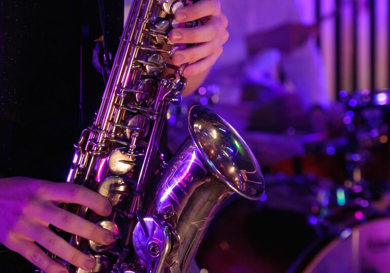 Jazz saxophonist with drums in background