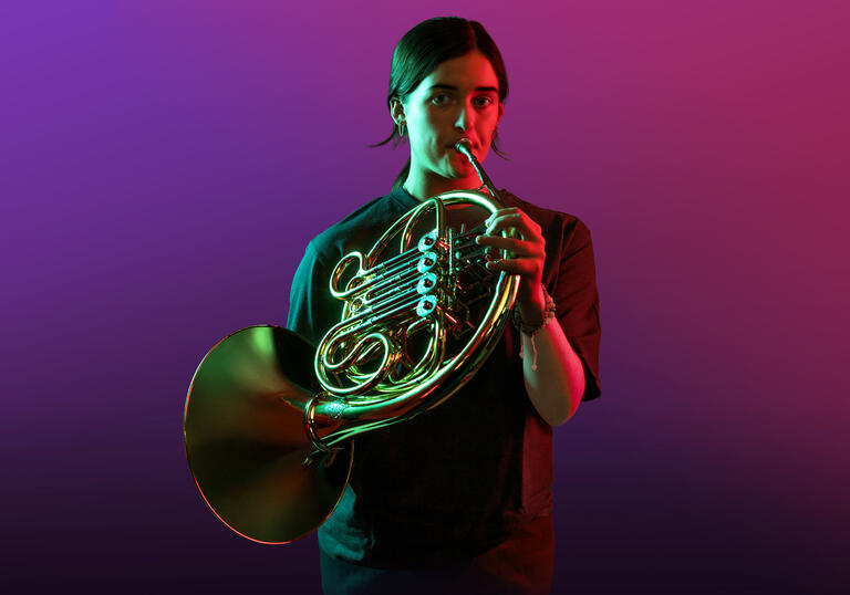 Horn player on a purple background