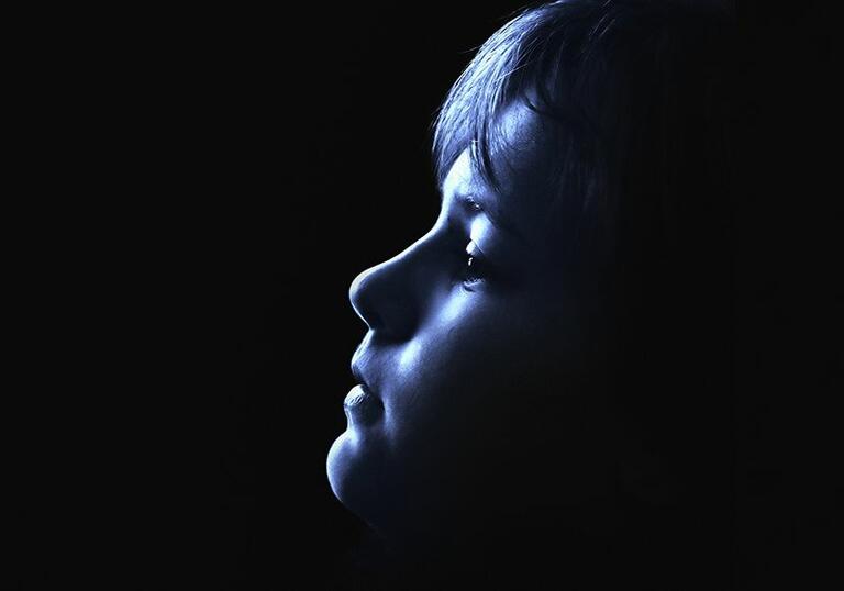 Image of young boy looking up with face in shadow
