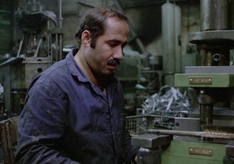 A man in overalls working with heavy machinery