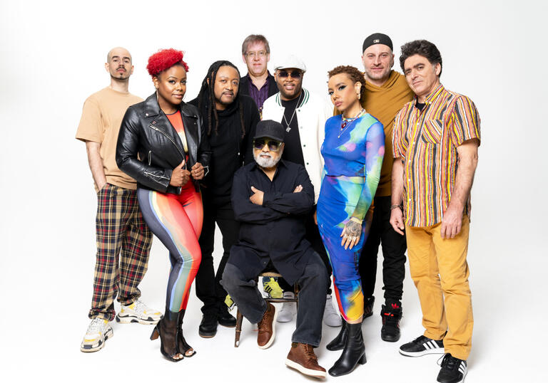 A photo of 9 people, members of Incognito posing in front of a white background