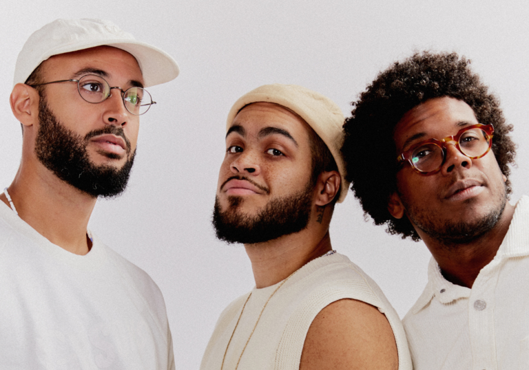 Three black men. members of Gilsons, dressed in white