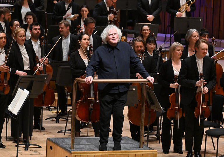 Sir Simon Rattle facing the audience in the Barbican concert hall