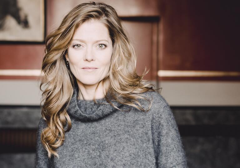 A portrait photo of Barbara Hannigan, wearing a grey jumper and facing the camera