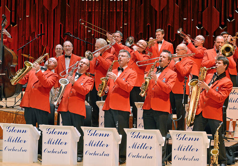 Mid-performance image of the Glenn Miller Orchestra all wearing red suits 