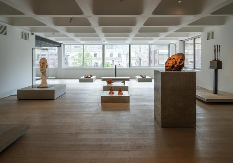 A shot of the Level 2 gallery showing works by Huma Bhabha and Alberto Giacometti on concrete plinths.