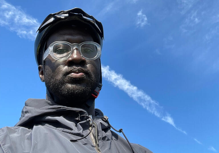 Image of Kwes taken from a low angle with the background of the sky