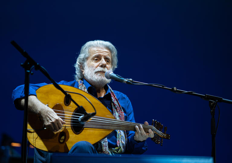 Mid performance shot of Marcel Khalife playing the oud.