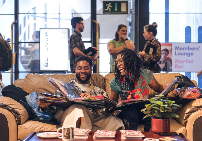 Two people sitting at a sofa