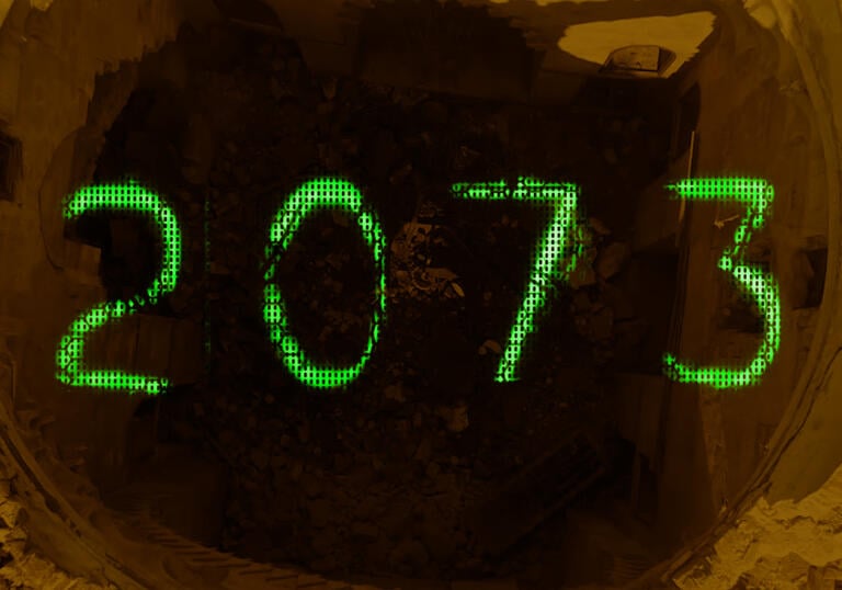 Green writing spells out 2073 over a pile of rubble