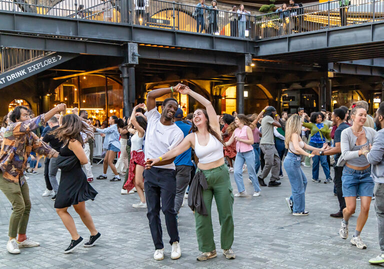 A group of people dance smiling