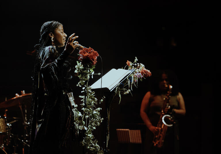aja monet singing in front of a jazz band
