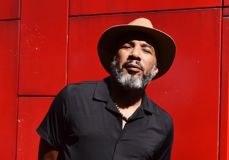 Image of Anthony Joseph in a hat against a red background