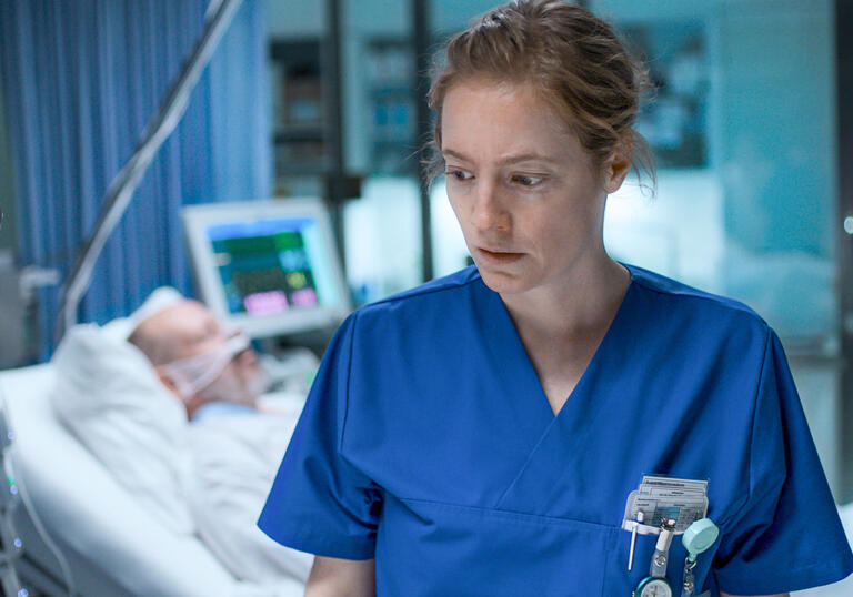 A young woman in a blue nurse uniform