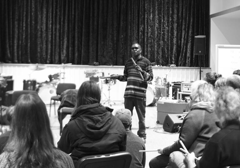 A black and white photo of a flute performer in front of an audience