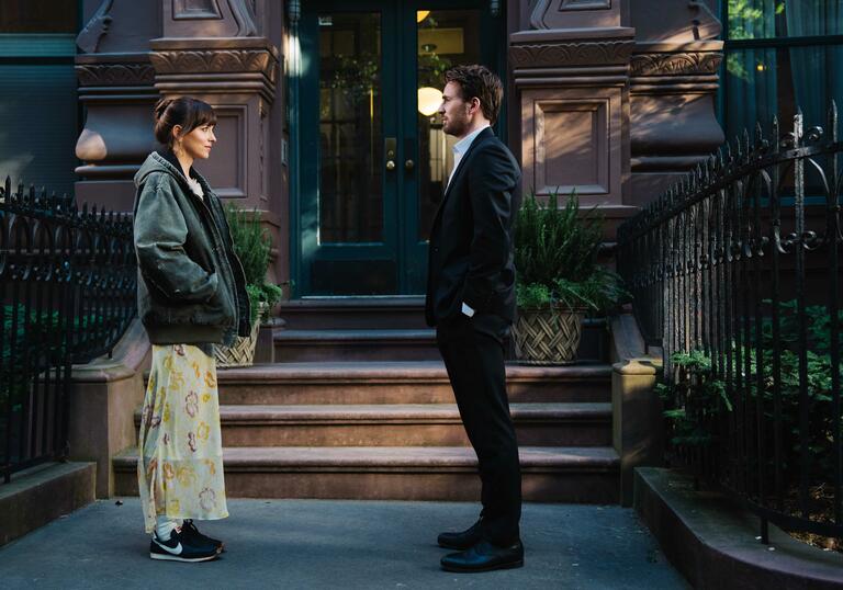 A man and a woman facing each other on the street.