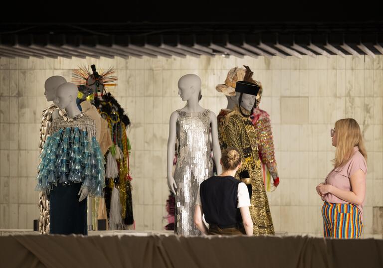 A shot of into one of the exhibition bays, showing a collection of clothing designs on mannequins.