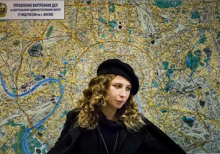 Portrait of Maria Alyokhina against a background of a map