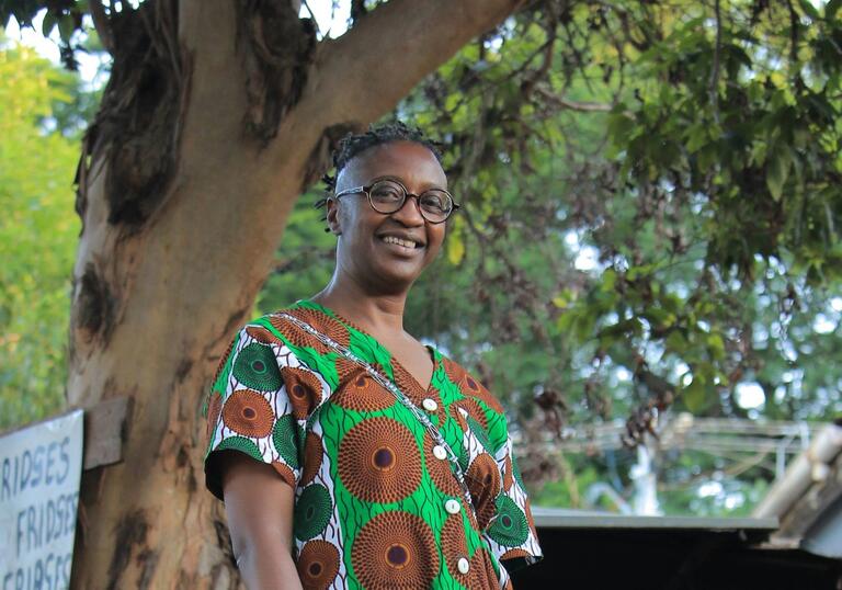 DJ SNO standing in front of a tree surrounded by nature 
