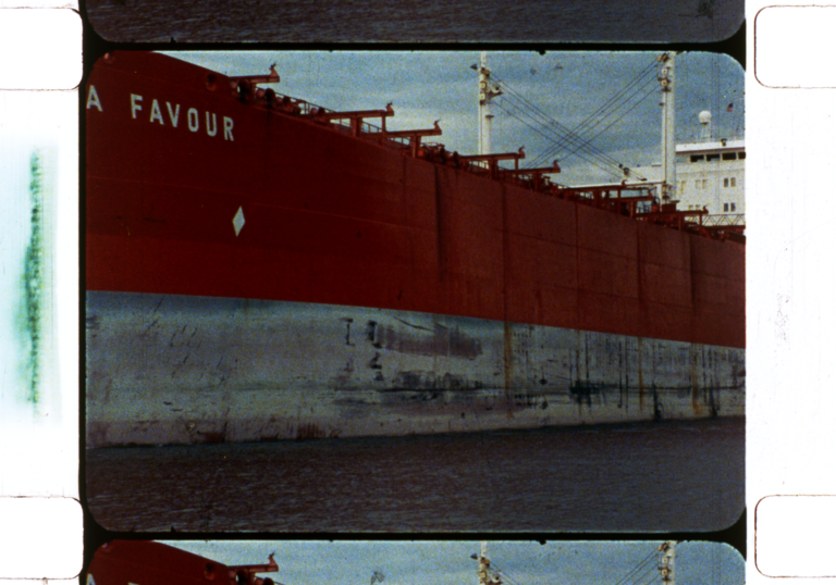 A red large boat shot on 35mm against a blue sky.