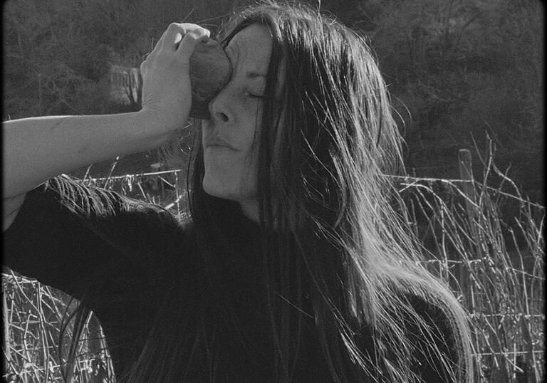 A woman holding something to her face