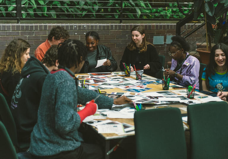 A group of young people sitting around a table doing crafts