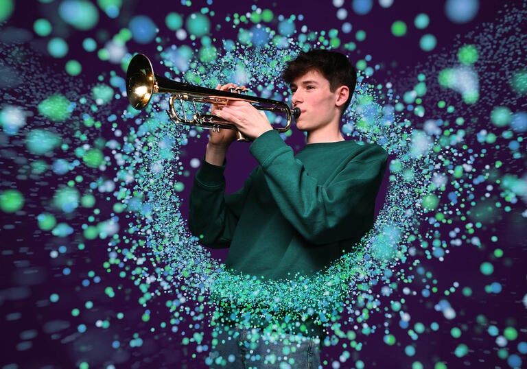 Image of  aperson playing the violin edited to be surrounded by shimmering green orbs of light