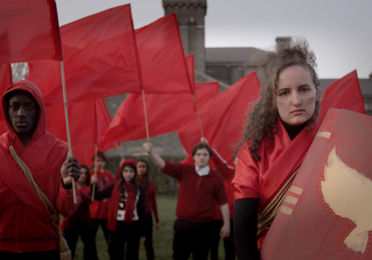 A group wearing red clothes and waving red flags