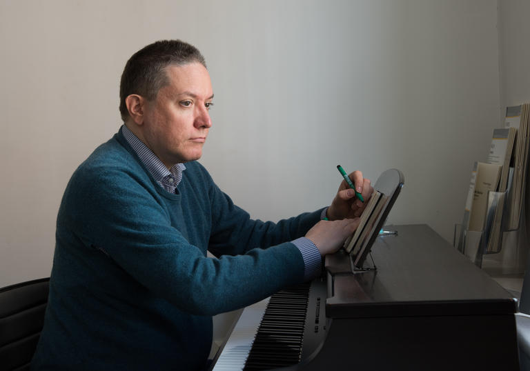 A picture of Julian Anderson writing at the piano
