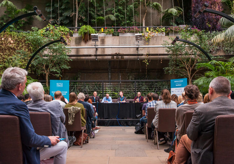 An audience watching a talk in the Barbican Conservatory