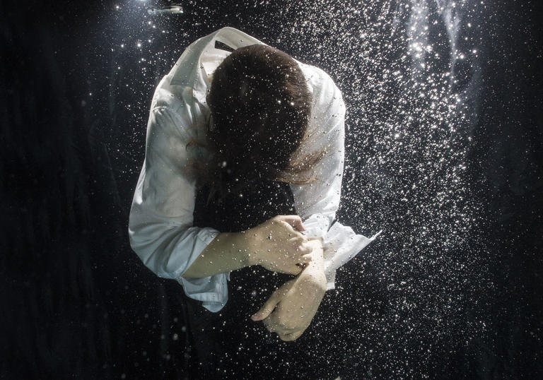 Photo of a figure floating under water