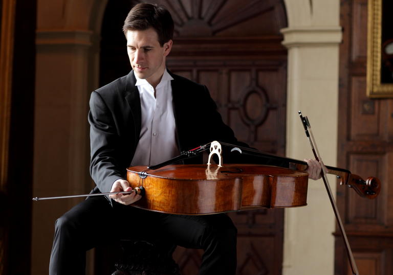 A picture of Guy Johnson holding a cello