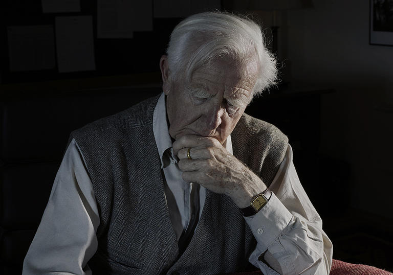 Photo of an old man reading a book